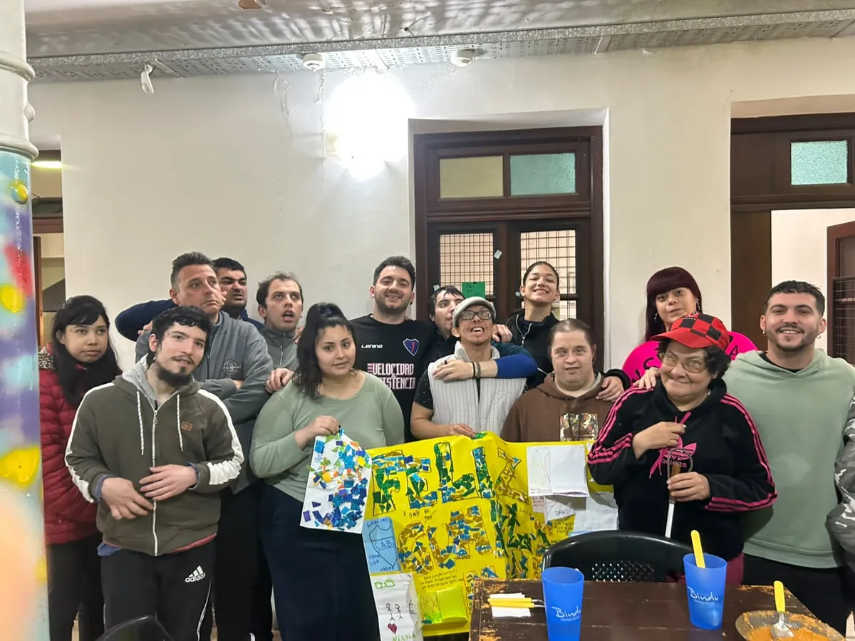 Grupo de concurrentes y profesionales de Bindu posando juntos con carteles hechos a mano en un festejo del centro