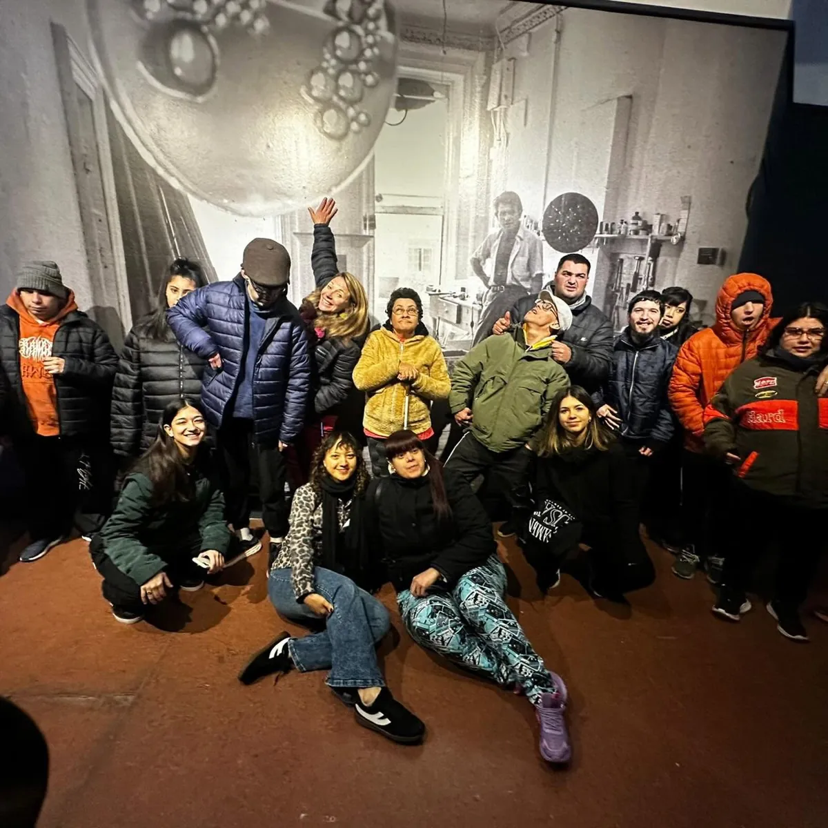 Grupo posando frente a una muestra fotográfica en una visita a un museo