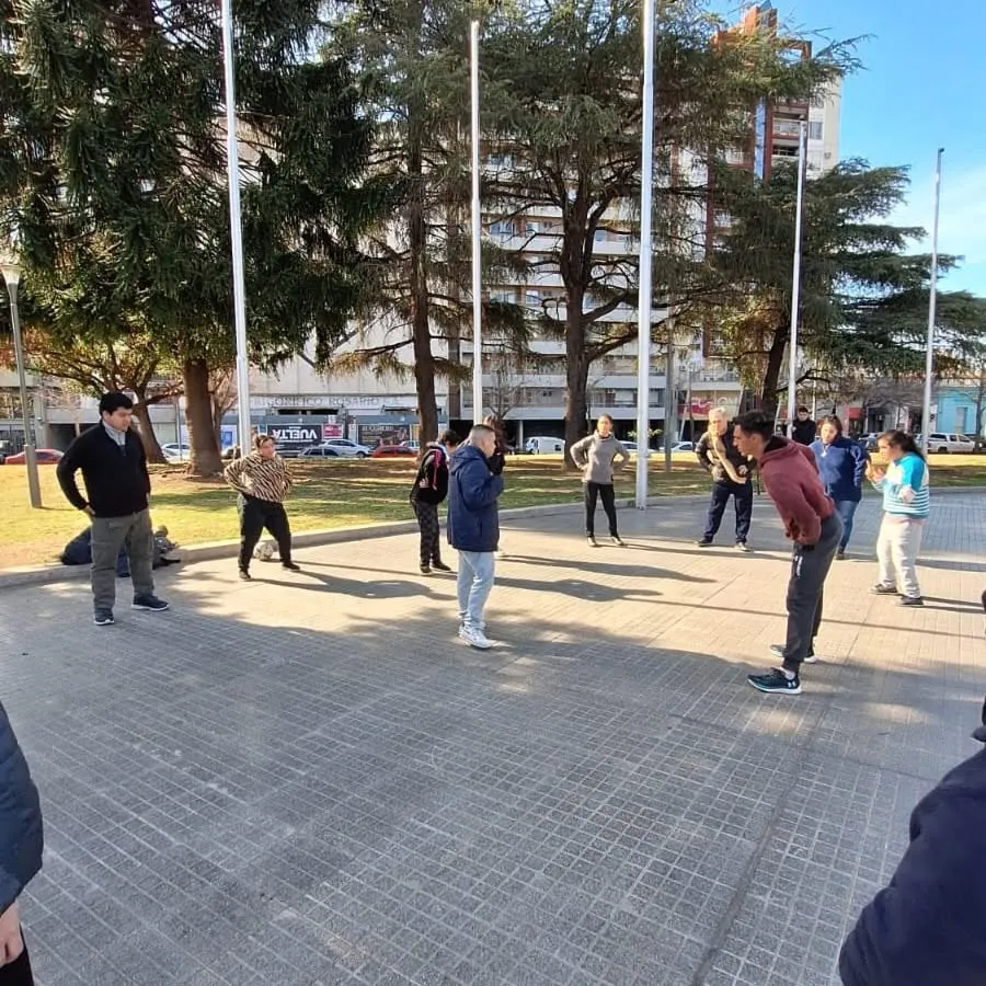 Concurrentes realizando una actividad física grupal al aire libre en una plaza